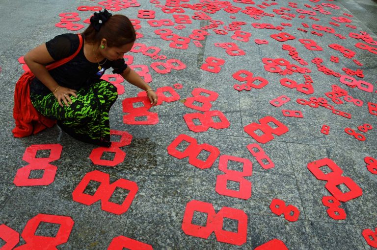 An activist places cutouts on the ground in Mahabandoola Park in Yangon on August 8, 2016 to mark the 28th anniversary of a general strike, one of the key events of the 1988 uprising. (AFP)