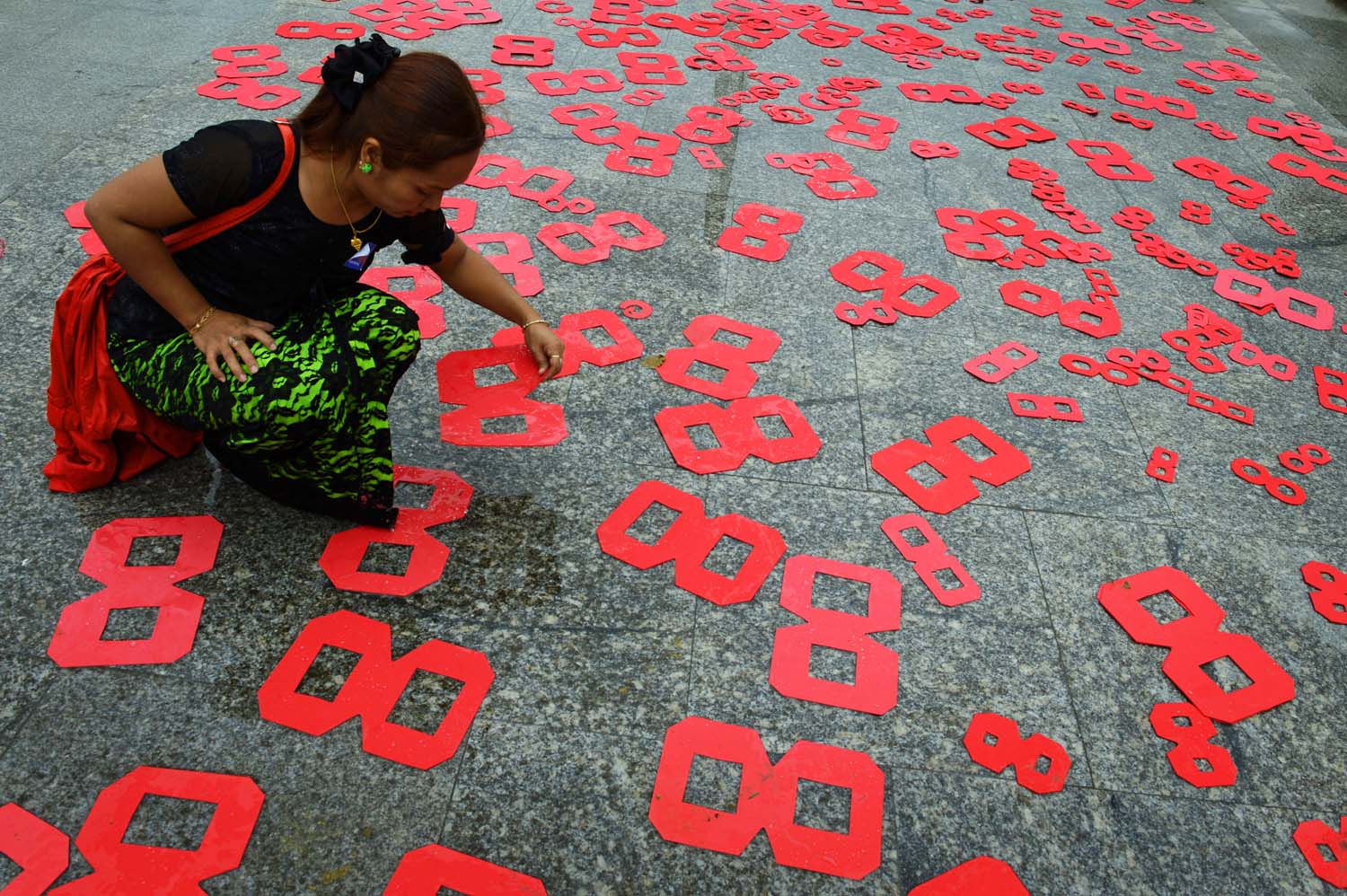 An activist places cutouts on the ground in Mahabandoola Park in Yangon on August 8, 2016 to mark the 28th anniversary of a general strike, one of the key events of the 1988 uprising. (AFP)