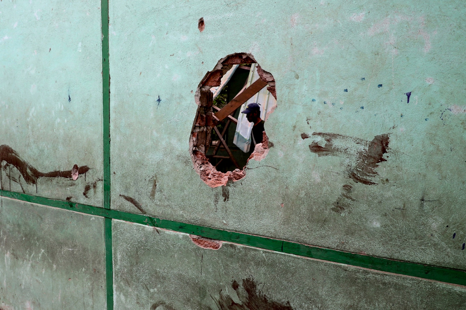 A man is seen through a damaged wall of a school in Oh Htein Twin village, in Sagaing Region’s Tabayin Township, following a regime airstrike on May 12, 2025. (AFP)