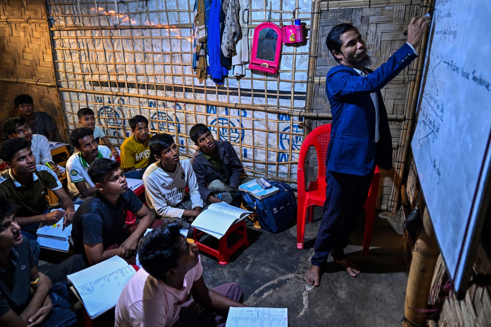 Mohammad Amin, a Rohingya refugee and teacher, conducts a class in a makeshift learning centre at the Kutupalong refugee camp in Bangladesh on December 17, 2025. (AFP)