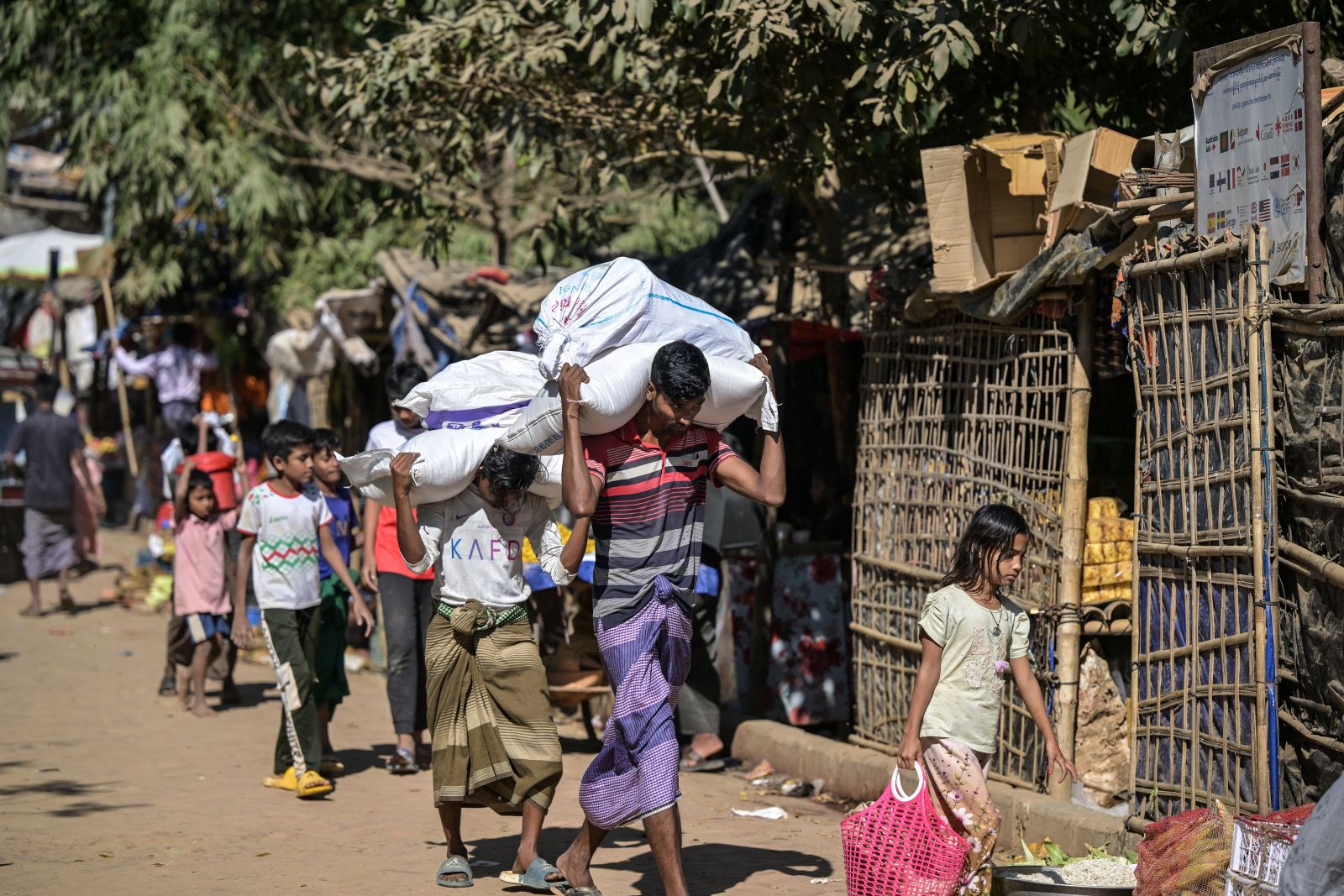 Rohingya youths carry sacks of relief aid at the Kutupalong refugee camp, in Bangladesh’s Cox’s Bazar disctrict, on December 20, 2025. (AFP)