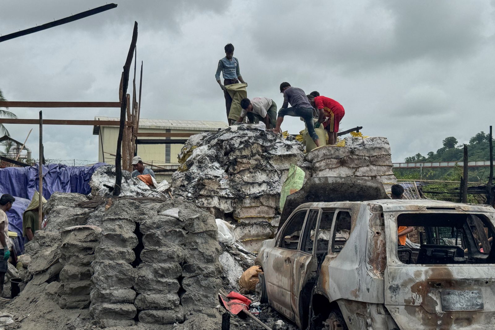 People clear debris after a regime airstrike in Rakhine State’s Kyauktaw town on June 18. (AFP)