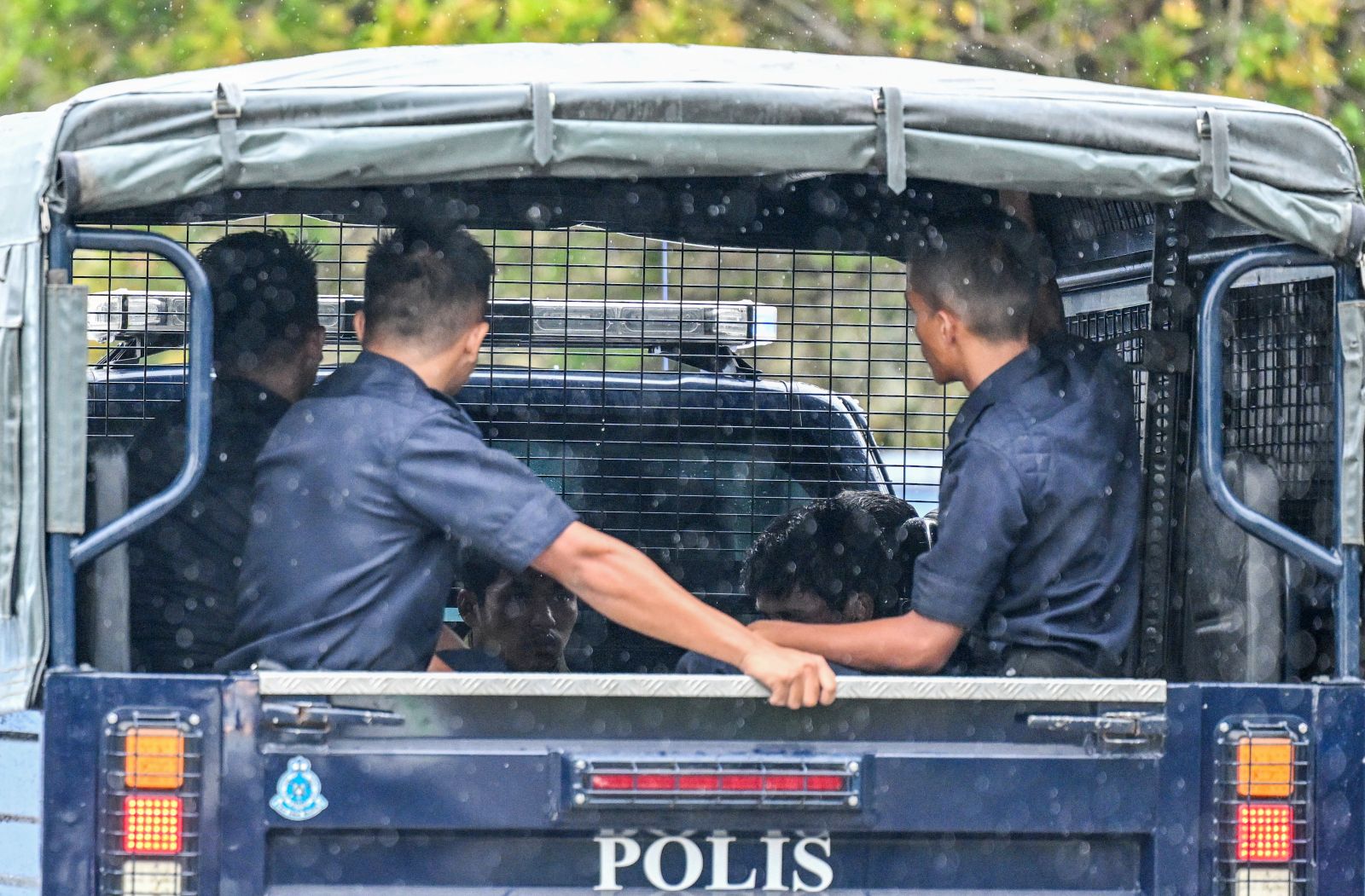 Malaysian police escort detainees towards the immigration detention centre in Bidor town, in Malaysia's northern Perak state, on February 2, 2024. (AFP)
