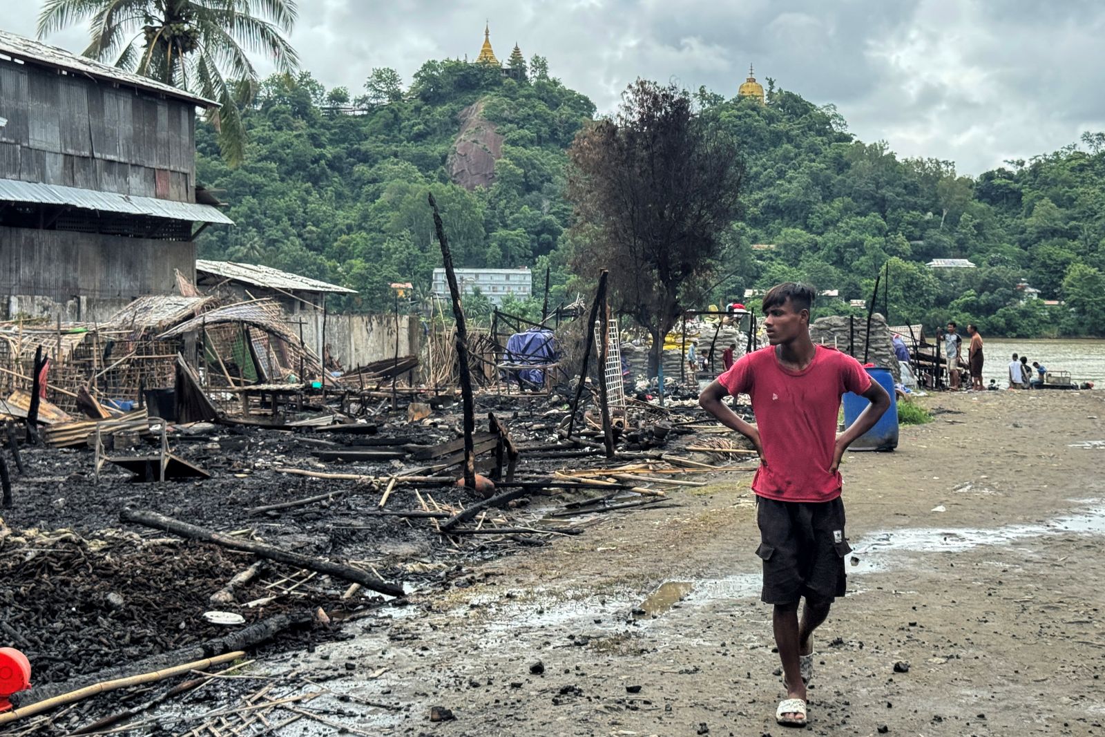 A man walks past a building destroyed by a regime airstrike in Rakhine State’s Kyauktaw town on June 18. (AFP)