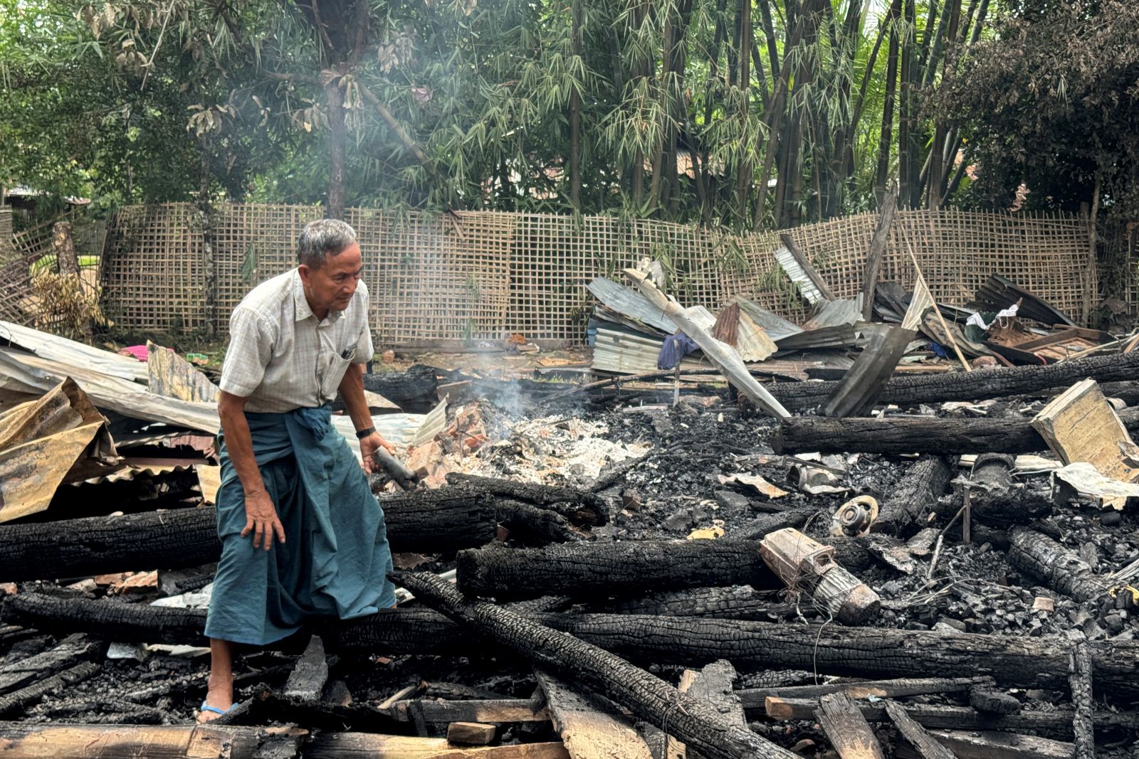 A man clears debris after a regime airstrike in Rakhine State’s Kyauktaw town on June 18. (AFP)