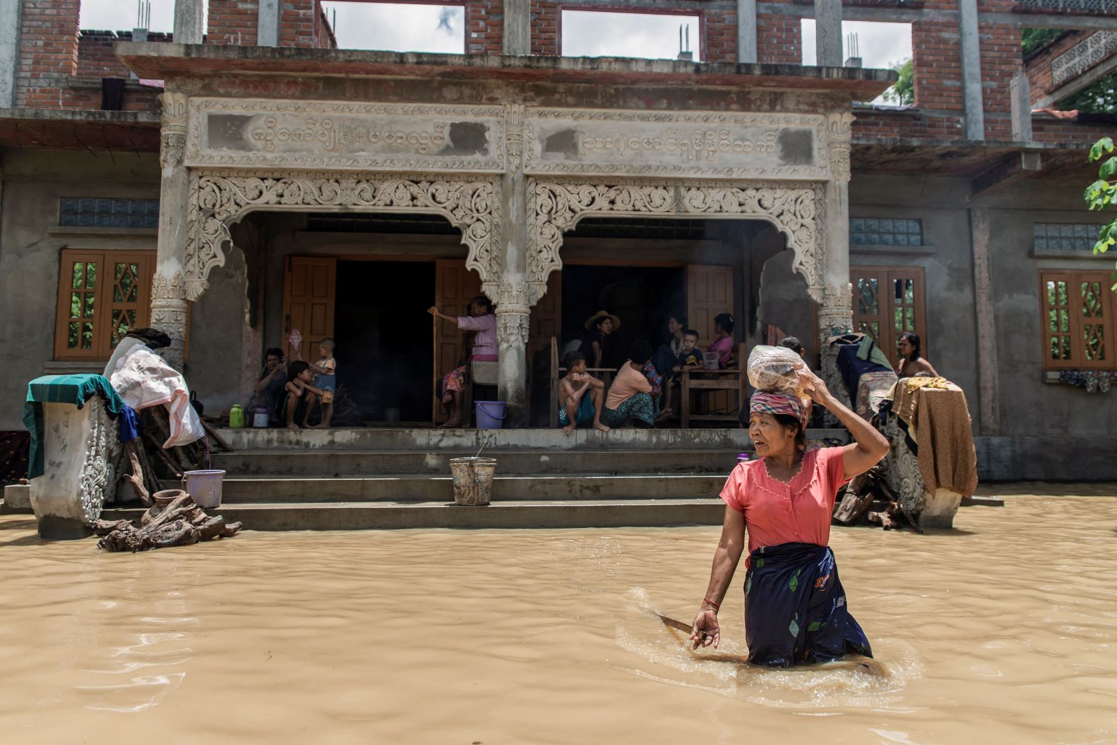 A woman wades through a flooded area in Sagaing Region’s Wetlet Township on August 10. (AFP)