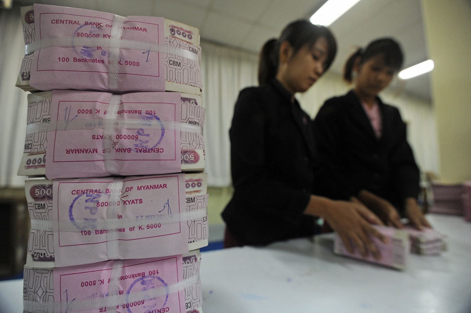 Employees handle bank notes at the Central Bank of Myanmar in Yangon on June 27, 2012. (AFP)