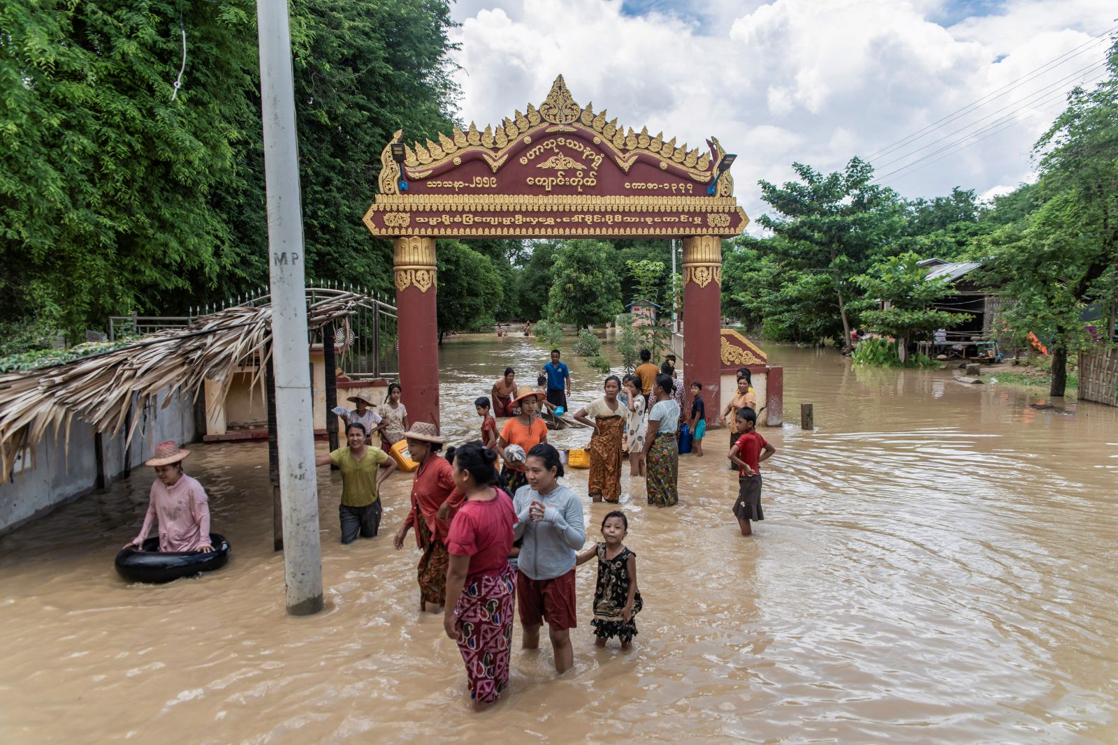 People stand in a flooded area in Sagaing Region’s Wetlet Township on August 10. (AFP)