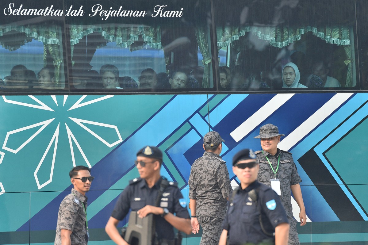 A bus carrying Myanmar nationals being repatriated from Malaysia heads toward a navel base in Lumut, on the outskirts of Kuala Lumpur, on September 29. (AFP)